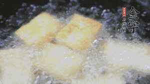 鍋中倒入油，油燒熱，豆腐塊放入油中炸至外面呈現淺黃色，撈出后，再復炸至金黃色。（經過復炸后，豆腐塊表面是脆的，而里面還是嫩的）