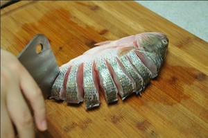 將鱸魚(yú)清洗干凈，從脊椎處切斷至腹部，腹部保留1cm左右不要切斷。