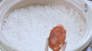 煮開后轉小火，當米飯出現小孔時，鋪上金字麻辣香腸。