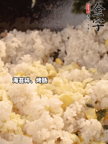 剩米飯下鍋炒散，依次下玉米粒、雞蛋、烤腸、海苔碎翻炒均勻。
