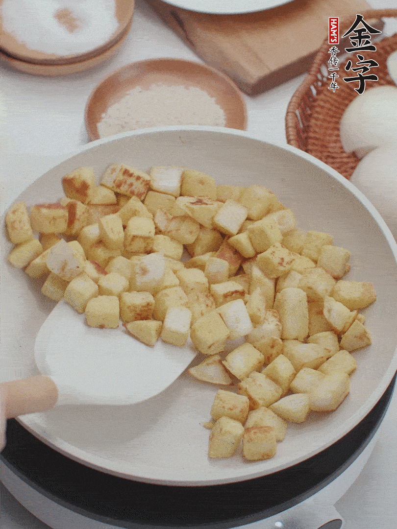 起鍋熱油，倒入饅頭丁，小火煎至蛋液凝固定型再翻面，饅頭丁部煎至金黃時盛起待用。