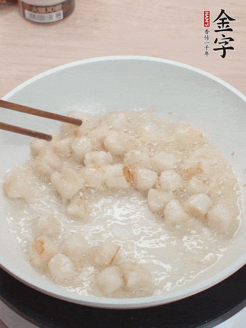 油溫4成熱，鮮貝蘸干淀粉下鍋煎，一面微黃后翻面。