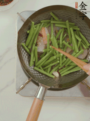 下掰好的缸豆段翻炒，略燜煮。