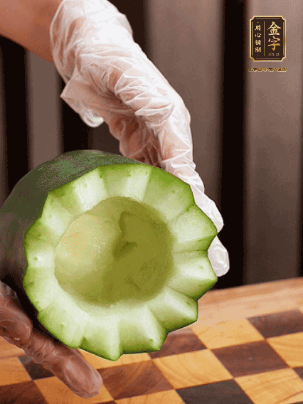 將小冬瓜洗凈，頂端切開(kāi)去瓜瓤，改刀切口呈鋸齒狀