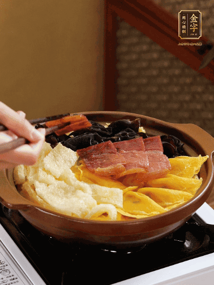 砂鍋底部鋪上娃娃菜，依次擺上肉皮、蛋餃、黑木耳、火腿